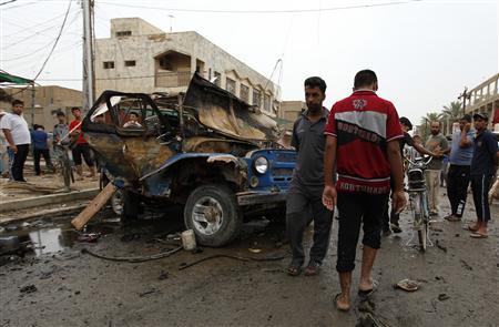 Residents gather at the site of a car bomb attack at the Kamaliya district in Baghdad May 20, 2013. REUTERS/Mohammed Ameen