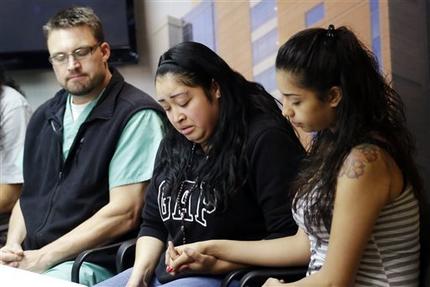 FILE - In this May 2, 2013, file photo, Johana Portillo, center, and her sister Ana Portillo hold hands while Dr. Shawn Smith looks on during a news conference at Intermountain Medical Center, in Murray, Utah. A Utah prosecutor said Monday, May 6, he plans to decide soon what charges to file against a teenager accused of punching Ricardo Portillo, a soccer referee who later died after slipping into a weeklong coma. (AP Photo/Rick Bowmer, File)