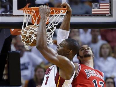 Miami Heat's Chris Bosh (L) slam dunks over Chicago Bulls' Joakim Noah during Game 2 of their NBA Eastern Conference semi-final basketball playoff in Miami, Florida May 8, 2013. REUTERS/Joe Skipper