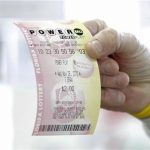 FILE - This Nov. 28, 2012, file photo shows a customer at a 7-Eleven convenience store with a Powerball ticket in Tampa, Fla. The jackpot for the latest drawing on Wednesday, May, 15, 2013, has ballooned to an estimated $360 million, with a cash value of $229.2 million, making it the third largest Powerball jackpot and the seventh largest jackpot ever. (AP Photo/Chris O'Meara, File)