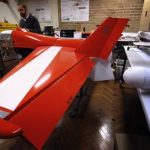 Salah Sukkarieh, professor of Robotics and Intelligent Systems at the University of Sydney, Australian Centre for Field Robotics, stands next to one of his robotic aircraft in his laboratory in Sydney April 24, 2013. REUTERS/David Gray