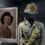 In this May 23, 2013 photo, a page of out of the diary of 22-year-old Marine Cpl. Thomas Jones featuring a photo of his high school sweetheart, Laura Mae Davis Burlingame, is on display at the National WWII Museum in New Orleans. Behind is a Marine uniform like one Jones, who died in the bloody assault on a Japanese-held island during World War II, would have worn. Before Jones died, he wrote what he called his last life request to anyone who might find his diary: Please give it to Laura Mae Davis, the girl he loved. Laura Mae Davis Burlingame _ she married an Army Air Corps man in 1945 _ had given the diary to Jones, and didnt know it had survived him until visiting the museum on April 24. (AP Photo/Gerald Herbert)