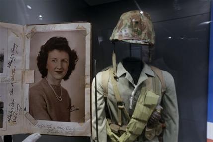 In this May 23, 2013 photo, a page of out of the diary of 22-year-old Marine Cpl. Thomas Jones featuring a photo of his high school sweetheart, Laura Mae Davis Burlingame, is on display at the National WWII Museum in New Orleans. Behind is a Marine uniform like one Jones, who died in the bloody assault on a Japanese-held island during World War II, would have worn. Before Jones died, he wrote what he called his last life request to anyone who might find his diary: Please give it to Laura Mae Davis, the girl he loved. Laura Mae Davis Burlingame _ she married an Army Air Corps man in 1945 _  had given the diary to Jones, and didnt know it had survived him until visiting the museum on April 24. (AP Photo/Gerald Herbert)