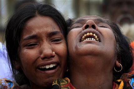A woman is comforted as she grieves after identifying the body of her daughter, a victim of the garment factory collapse, Sunday, May 5, 2013 in Savar, near Dhaka, Bangladesh. The death toll from the collapse of a shoddily built garment-factory building in Bangladesh continued its horrifying climb, reaching 580 on Sunday with little sign of what the final number will be. The disaster is likely the worst garment-factory accident ever, and there have been few industrial accidents of any kind with a higher death toll. (AP Photo/Wong Maye-E)