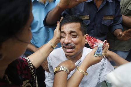 Colleagues comfort a company official as he cries after a fire at a factory belonging to Tung Hai Group, a large garment exporter, in Dhaka May 9, 2013. REUTERS/Andrew Biraj