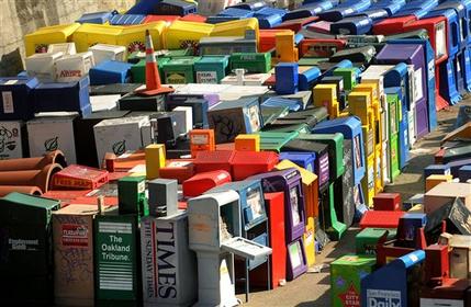 FILE-In this Friday, March 13, 2009, file photo, discarded newspaper racks clutter a storage yard in San Francisco. The report released Monday, May 13, 2013, revealing that the financial data and news company Bloomberg LP leaked more than 10,000 of its clients' private messages containing sensitive pricing data, highlights the uncertain and rapidly changing ethical landscape facing media companies that are reinventing the news business. Bloomberg LP, which started as a provider of sophisticated financial data to bond traders and only later expanded to include a journalistic enterprise, echoes many new ventures in its determination to bypass old journalistic models that depended on well-defined relationships with readers and advertisers. (AP Photo/Noah Berger, File)