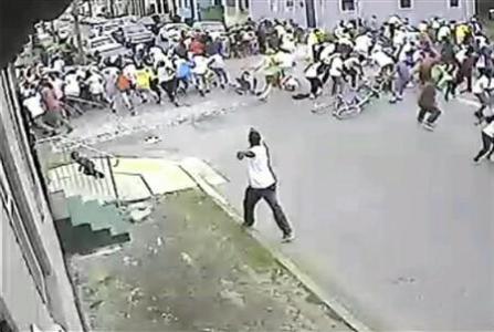 A still image taken from security camera video released by the New Orleans Police Department (NOPD) shows a gunman shooting into a crowd gathered for a Mother's Day second line parade in New Orleans, Louisiana May 12, 2013. REUTERS/NOPD8th/Handout via Reuters