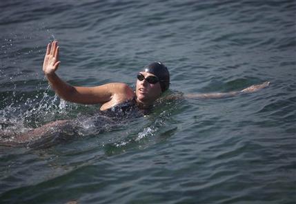 Australian swimmer Chloe McCardel waves to spectators as she begins her swim to Florida from the waters off Havana, Cuba, Wednesday, June 12, 2013. McCardel, 29, is bidding to become the first person to make the Straits of Florida crossing without the protection of a shark cage. American Diana Nyad and Australian Penny Palfrey have attempted the crossing four times between them since 2011, but each time threw in the towel part way through due to injury, jellyfish stings or strong currents. Australian Susie Maroney did it in 1997, but with a shark cage. (AP Photo/Ramon Espinosa)