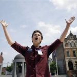 FILE - Christian Olivera, of Newark, N.J., shouts toward the Statehouse in Trenton, N.J. on Thursday, June 27, 2013 as he and other advocates for gay marriage in New Jersey gather, saying they'll press their case in the legislature and the courts after the U.S. Supreme Court ruling that invalidates parts of the federal Defense of Marriage Act. Gov. Chris Christie said he would again veto a same-sex marriage bill if it reaches his desk, and that Wednesday's U.S. Supreme Court ruling striking down a ban on federal benefits for same-sex married couples will have no effect on New Jersey, one of a handful of states that allows civil unions. (AP Photo/Mel Evans)