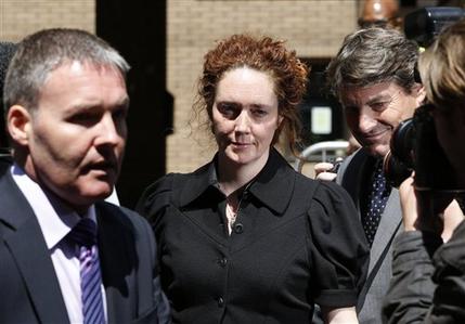 Former News International chief executive Rebekah Brooks, center, accompanied by her husband Charlie, right, leaves a court after entering a not guilty plea to charges related to phone hacking, in London, Wednesday, June 5, 2013. Brooks on Wednesday denied charges of phone hacking, bribing public officials and trying to thwart a police investigation into tabloid wrongdoing. (AP Photo/Lefteris Pitarakis)