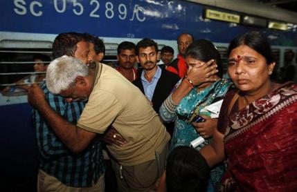 Indian pilgrim Rahava Chary, second from left, who was stranded after flash floods and landslides in Uttarakhand state, hugs his family members on his arrival in Hyderabad, India, Tuesday, June 25, 2013. An air force helicopter returning from a rescue mission in flood-ravaged northern India hit the side of a mountain and fell into a river on Tuesday, killing eight people, officials said. Bad weather has hampered rescue efforts in Uttarakhand state, where more than 1,000 people are believed to have died and thousands of others remain stranded in remote areas because of landslides and floods triggered by torrential monsoon rains. (AP Photo/Mahesh Kumar A.)
