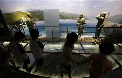 Kindergarten pupils walk by an exhibit dipicting South Korean soldiers during the Korean War at the Korea War Memorial Museum in Seoul, South Korea, Friday, June 7, 2013. North Korea on Friday proposed holding low-level government talks with South Korea this weekend as the rivals look to mend ties that have plunged during recent years amid hardline stances by both countries. (AP Photo/Lee Jin-man)