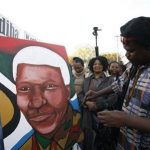Lebani Sirinje, a Zimbabwean artist paints a portrait of former South African President Nelson Mandela, outside the Mediclinic Heart Hospital where is being treated in Pretoria, South Africa Wednesday, June 26, 2013. South Africa's president Jacob Zuma on Tuesday urged his compatriots to show their appreciation for Nelson Mandela, who is in critical condition in a hospital, by marking his 95th birthday next month with acts of goodness that honor the legacy of the anti-apartheid leader. (AP Photo/Themba Hadebe)