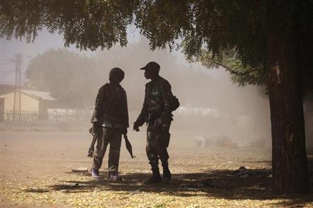 Malian soldiers talk to each other in a cloud of dust during fighting with Islamists in Gao February 21, 2013. REUTERS/Joe Penney
