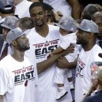 Miami Heat players Dwyane Wade, left, Chris Bosh and LeBron James talk following the presentation of the NBA Eastern Conference trophy following Game 7 in their NBA basketball Eastern Conference finals playoff series against the Indiana Pacers, Tuesday, June 4, 2013 in Miami. The Heat defeated the Pacers 99-76 to advance to the NBA finals against the San Antonio Spurs. (AP Photo/Wilfredo Lee)