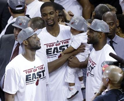 Miami Heat players Dwyane Wade, left, Chris Bosh and LeBron James talk following the presentation of the NBA Eastern Conference trophy following Game 7 in their NBA basketball Eastern Conference finals playoff series against the Indiana Pacers, Tuesday, June 4, 2013 in Miami. The Heat defeated the Pacers 99-76 to advance to the NBA finals against the San Antonio Spurs. (AP Photo/Wilfredo Lee)