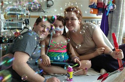 FILE - In this May 30, 2013 file photo provided by the Murnaghan family, Sarah Murnaghan, center, celebrates the 100th day of her stay in Children's Hospital of Philadelphia with her father, Fran, left, and mother, Janet. The 10-year-old Pennsylvania girl, who underwent a double-lung transplant amid a national debate over the organ allocation process, has undergone a second transplant after the first failed and is now taking some breaths on her own, her parents said Friday, June 28, 2013. (AP Photo/Murnaghan Family, File)