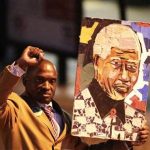 A well-wisher carries a portrait of former South African President Nelson Mandela outside the Pretoria hospital where former President Mandela is being treated, June 26, 2013. REUTERS/Siphiwe Sibeko