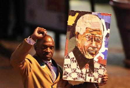 A well-wisher carries a portrait of former South African President Nelson Mandela outside the Pretoria hospital where former President Mandela is being treated, June 26, 2013. REUTERS/Siphiwe Sibeko