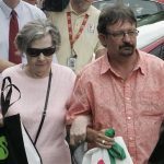Powerball winner Gloria C. Mackenzie, 84, left, leaves the lottery office escorted by her son, Scott Mackenzie, after claiming a single lump-sum payment of about $370.9 million before taxes on Wednesday, June 5, 2013, in Tallahassee, Fla. Officials say she is the largest sole lottery winner in U.S. history. She did not speak to reporters outside lottery headquarters, leaving in a silver Ford Focus with family members. (AP Photo/Steve Cannon)
