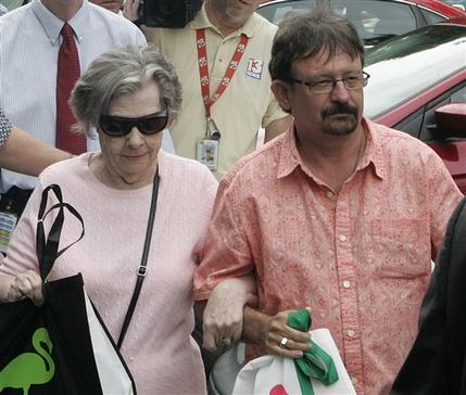 Powerball winner Gloria C. Mackenzie, 84, left, leaves the lottery office escorted by her son, Scott Mackenzie, after claiming a single lump-sum payment of about $370.9 million before taxes on Wednesday, June 5, 2013, in Tallahassee, Fla. Officials say she is the largest sole lottery winner in U.S. history. She did not speak to reporters outside lottery headquarters, leaving in a silver Ford Focus with family members. (AP Photo/Steve Cannon)