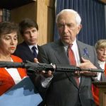 FILE - In this June 16, 1999 file photo, Sen. Frank Lautenberg, D-N.J., displays an AR-15 carbine at a news conference on Capitol Hill where he and other Democrats urged the House to pass his version of gun control legislation. Lautenberg, a longtime advocate of gun control, died Monday, June 3, 2013, at age 89. He returned to the Senate in April 2013 despite poor health for several votes on gun legislation favored by President Barack Obama. In the background are, from left to right: Rep. Nikta Lowey, D-N.Y.; Rep. Rod Blagojevich, D-Ill.; Rep. Carolyn McCarthy, D, N.Y. (AP Photo/Dennis Cook, File)