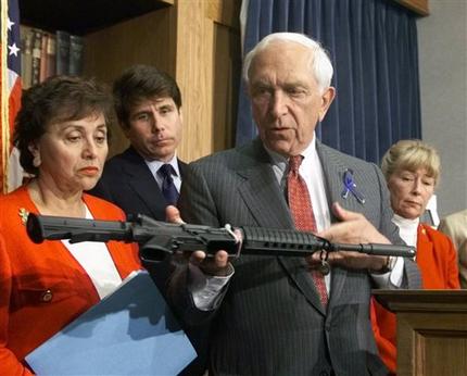 FILE - In this June 16, 1999 file photo, Sen. Frank Lautenberg, D-N.J., displays an AR-15 carbine at a news conference on Capitol Hill where he and other Democrats urged the House to pass his version of gun control legislation. Lautenberg, a longtime advocate of gun control, died Monday, June 3, 2013, at age 89. He returned to the Senate in April 2013 despite poor health for several votes on gun legislation favored by President Barack Obama. In the background are, from left to right: Rep. Nikta Lowey, D-N.Y.; Rep. Rod Blagojevich, D-Ill.; Rep. Carolyn McCarthy, D, N.Y. (AP Photo/Dennis Cook, File)