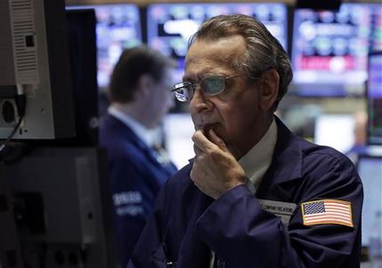 Specialist Joseph Quaglieri looks at a monitor as he works on the floor of the New York Stock Exchange, Thursday, June 20, 2013. Financial markets are sliding after the Federal Reserve said it could end its huge bond-buying program by the middle of next year. (AP Photo/Richard Drew)
