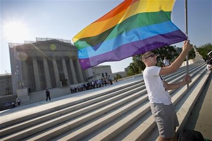 Vin Testa of Washington waves a rainbow flag in support of gay rights outside the Supreme Court in Washington, Tuesday, June 25, 2013, as key decisions are expected to be announced. The Supreme Court resolved five cases, including affirmative action, on Monday. That leaves disputes about gay marriage and voting rights among the six remaining cases. The justices are meeting again Tuesday to issue some opinions and will convene at least one more time. (AP Photo/J. Scott Applewhite)