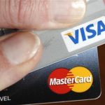 A credit card user displays her cards in Washington February 22, 2010. REUTERS/Kevin Lamarque