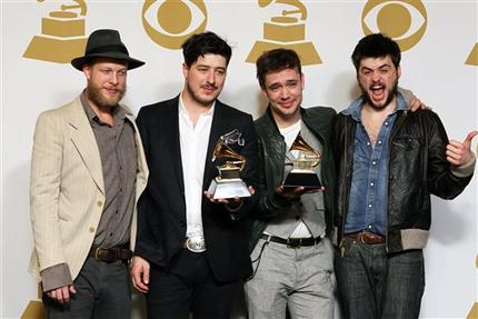 FILE - In this Feb. 10, 2013 file photo, members of the musical group Mumford & Sons, from left, Ted Dwane, Marcus Mumford, Ben Lovett and Winston Marshall, pose backstage with the best long form music video award for "Big Easy Express" and the album of the year award for "Babel" at the 55th annual Grammy Awards in Los Angeles. The band on Thursday, June 13, 2013 announced it has canceled its headlining performance at Bonnaroo Music & Arts Festival in Tennessee. The decision comes after Dwane received treatment this week for a blood clot on his brain. (Photo by Matt Sayles/Invision/AP, File)