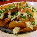 Potato chips with blue cheese dressing, green onions and tomatoes