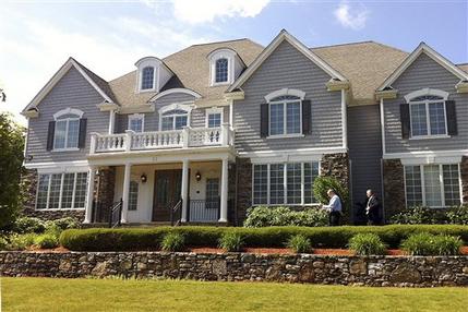Two members of the Massachusetts State Police walk toward the front door of the home of New England Patriot's NFL football player Aaron Hernandez in North Attleborough, Mass., Wednesday, June 19, 2013. Their knock on the door went unanswered. State and local police spent hours at the home Tuesday as another group of officers searched an industrial park about a mile away where a body was discovered the day before.  (AP Photo/Erika Niedowski)
