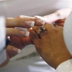 A woman puts a ring on the hand of another woman in a civil union ceremony after Colorado's civil union law went into effect in Denver May 1, 2013. REUTERS/Rick Wilking