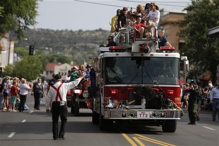 A fire truck carrying friends and family members of the Granite Mountain Interagency Hotshot Crew leads the Prescott Frontier Days Rodeo Parade Saturday, July 6, 2013 in Prescott, Ariz. The firefighters were killed battling a wildfire near Yarnell, Ariz., Sunday, June 30. (AP Photo/Chris Carlson)