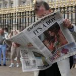 A man reads a newspaper carrying front page news of the birth of a baby boy of Prince William and Kate, Duchess of Cambridge, outside Buckingham Palace in London, Tuesday, July 23, 2013. (AP Photo/Sang Tan)