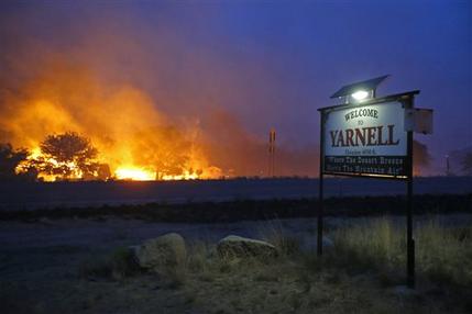 A wildfire burns homes in Yarnell, Ariz. on Sunday, June 30, 2013. An Arizona fire chief says the wildfire that killed 19 members of his crew near the town was moving fast and fueled by hot, dry conditions. The fire started with a lightning strike on Friday and spread to 2,000 acres on Sunday amid triple-digit temperatures. (AP Photo/The Arizona Republic, David Kadlubowski)