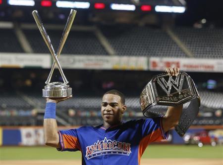 American League batter Yoenis Cespedes, of the Oakland A's, holds up the Home Run trophy and a belt after winning the Major League Baseball All-Star Game Home Run Derby in New York, July 15, 2013. REUTERS/Shannon Stapleton