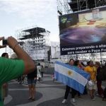 Argentinian pilgrims takes pictutres in Rio de Janeiro Sunday July 21, 2013, with a giant television monitor erected for the papal visit in the background. Pope Francis arrives July 22 in Rio de Janeiro for the World Youth Day.(AP Photo/Jorge Saenz)