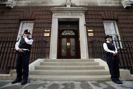 British police officers guard the entrance of St. Mary's Hospital exclusive Lindo Wing in London, Monday, July 22, 2013. Buckingham Palace officials say Prince William's wife, Kate, has been admitted to the hospital in the early stages of labour. Royal officials said that Kate traveled by car to St. Mary's Hospital in central London. Kate _ also known as the Duchess of Cambridge _ is expected to give birth in the private Lindo Wing of the hospital, where Princess Diana gave birth to William and his younger brother, Prince Harry.The baby will be third in line for the British throne _ behind Prince Charles and William _ and is anticipated eventually to become king or queen. (AP Photo/Lefteris Pitarakis)