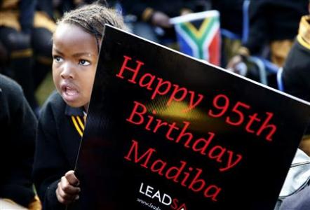 Children hold placards as they gather to wish to former President Nelson Mandela happy birthday at a township school in Atteridgeville near Pretoria, July 18, 2013. Anti-apartheid hero Mandela is "steadily improving", South Africa's government said on Thursday as the former president celebrated his 95th birthday in hospital amid tributes from around the country and the world. REUTERS/Mike Hutchings