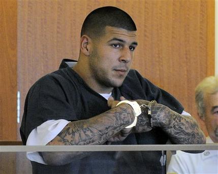 FILE - Former New England Patriots football tight end Aaron Hernandez stands during a bail hearing in Fall River Superior Court in this June 27, 2013 file photo taken in Fall River, Mass. An associate of former New England Patriots tight end Aaron Hernandez said he was told Hernandez fired the shots that resulted in the death of a semi-pro football player, according to documents filed in Florida.  The records say Hernandez associate Carlos Ortiz told Massachusetts investigators that another man, Ernest Wallace, said Hernandez shot Lloyd in an industrial park near Hernandez's home in North Attleborough. (AP Photo/Boston Herald, Ted Fitzgerald, Pool)
