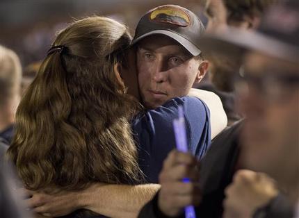 Firefighter Brendan McDonough embraces a mourner near the end of a candlelight vigil in Prescott, Ariz. on Tuesday, July 2, 2013. McDonough was the sole survivor of the 20-man Granite Mountain Hotshot Crew after an out-of-control blaze killed the 19 on Sunday near Yarnell, Ariz. (AP Photo/Julie Jacobson)