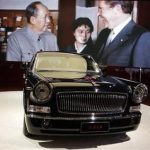 In this April 21, 2013 photo, the top of the line Hong Qi L9 is displayed near an image of then Chinese leader Mao Zedong meeting then U.S. President Richard Nixon at the Shanghai International Automobile Industry Exhibition (AUTO Shanghai) in Shanghai, China. China is reviving the illustrious Red Flag marque, better known at home by its Chinese name, Hong Qi, courtesy of a government-backed program to promote domestic brands that dovetails neatly with efforts to step-up Chinas diplomatic profile, partly through a greater emphasis on the pomp and circumstance accompanying state visits. The L9, is reserved for Chinese state leaders, flaunts a 6.4-meter (21-foot) armored chassis, suicide doors that open backward, and a price tag reported at around $1 million. (AP Photo/Eugene Hoshiko)