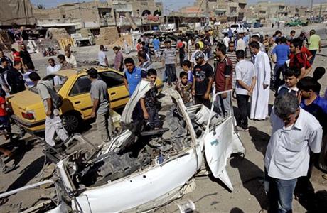 Iraqis inspect the aftermath of a car bomb attack
