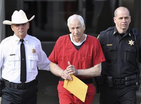 Jerry Sandusky (C) leaves the Centre County Courthouse after his sentencing in his child sex abuse case in Bellefonte, Pennsylvania October 9, 2012 file photo. REUTERS/Pat Little