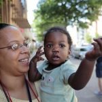 Ke'sha Scrivner, left, poses for a photograph after picking up her daughter Ka'Lani Scrivner, 1, from day care, Tuesday, July 9, 2013, in Washington. Once on welfare, Scrivner worked her way off by studying early childhood education and landing a full-time job for the District of Columbias education superintendent. She sees education as the path to a better life for herself and all five of her children, pushing them to finish high school and continue with college or a trade school. (AP Photo/Alex Brandon)