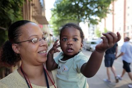 Ke'sha Scrivner, left, poses for a photograph after picking up her daughter Ka'Lani Scrivner, 1, from day care, Tuesday, July 9, 2013, in Washington. Once on welfare, Scrivner worked her way off by studying early childhood education and landing a full-time job for the District of Columbias education superintendent. She sees education as the path to a better life for herself and all five of her children, pushing them to finish high school and continue with college or a trade school. (AP Photo/Alex Brandon)