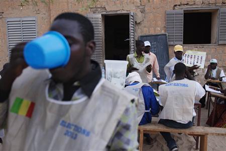 A poll worker breaks his Ramadan fast with water as other workers count ballots after the end of voting in Mali's presidential elections in Timbuktu July 28, 2013. REUTERS/Joe Penney