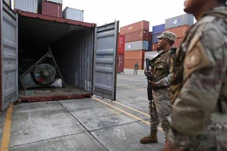 Panama police officers stand guard in front of a container holding a green missile-shaped object seized from the North Korean flagged ship "Chong Chon Gang" at the Manzanillo Container Terminal in Colon City July 17, 2013. REUTERS/Carlos Jasso